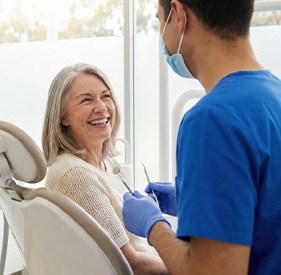 Happy senior patient talking with her dentist