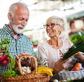 Happy senior couple shopping for produce