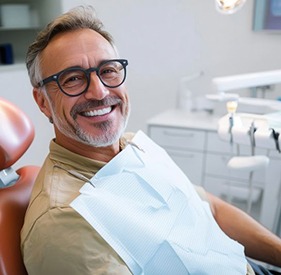 Happy, smiling dental patient in treatment chair